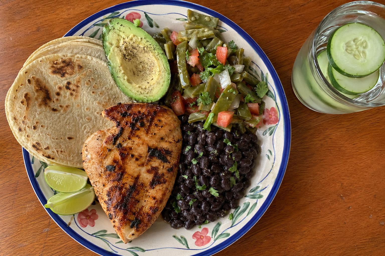 Plato mexicano con pollo a la parrilla, frijoles, ensalada de nopales y aguacate